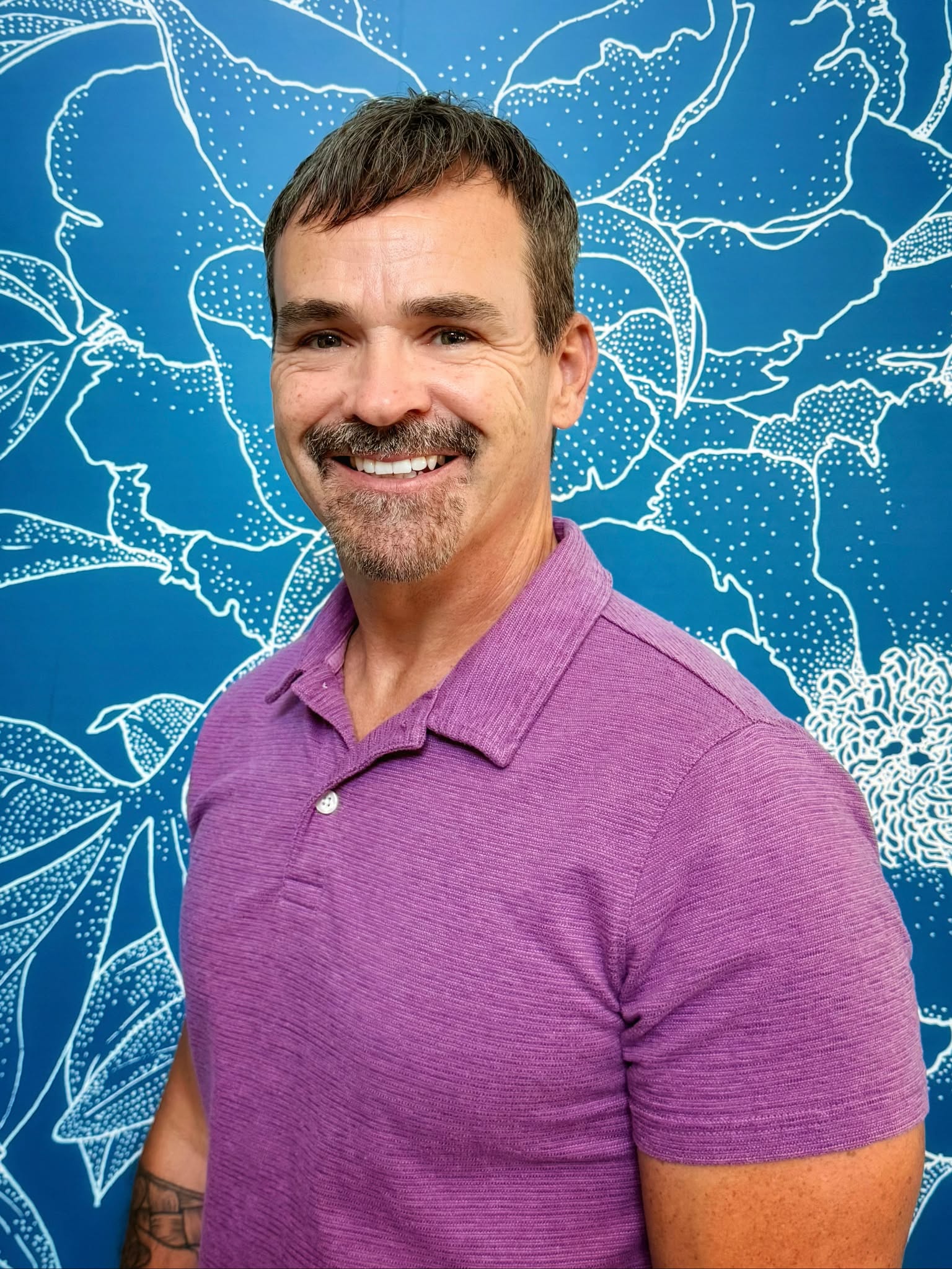 Portrait of the Grabbing for Grades founder wearing a purple polo shirt